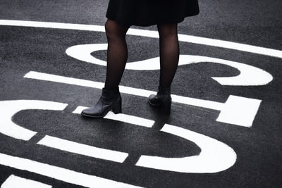 女人站在黑色的柏油路
